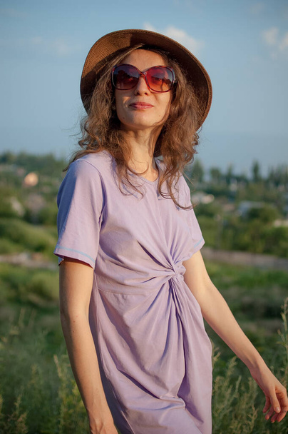 Mladá dívka v šatech se skvěle baví během dovolené v létě na obloze pozadí v přírodě, cestovní koncept - Fotografie, Obrázek