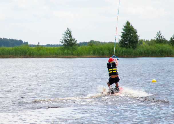 niño edad 9 montar wakeboard en el lago - Foto, Imagen