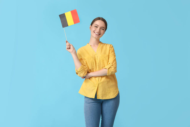 Jonge vrouw met vlag van België op kleur achtergrond - Foto, afbeelding