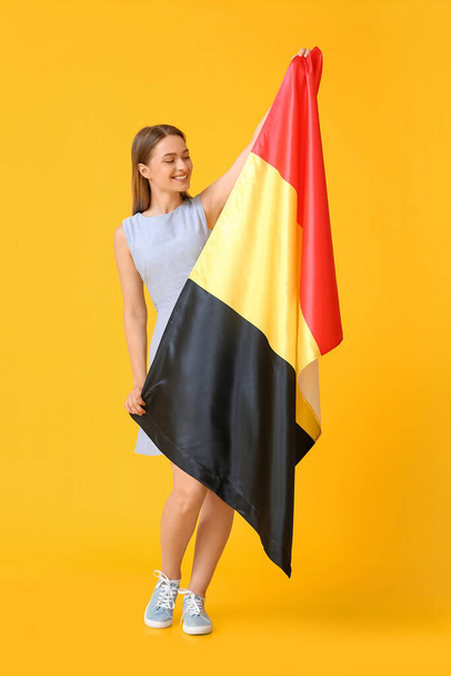 Młoda kobieta z flagą Belgii na tle koloru - Zdjęcie, obraz