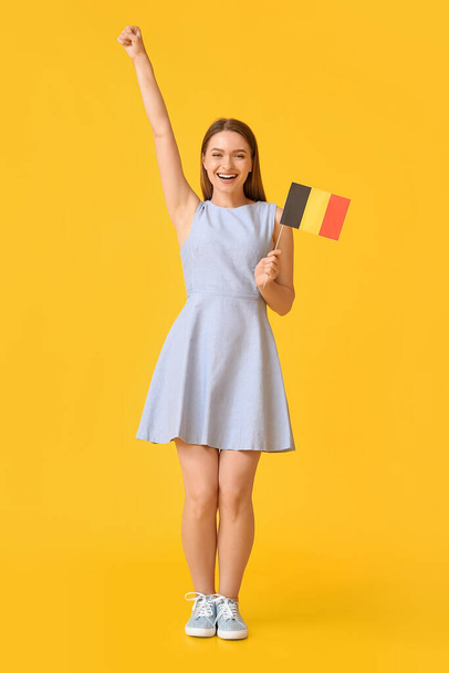 Szczęśliwa młoda kobieta z flagą Belgii na tle koloru - Zdjęcie, obraz