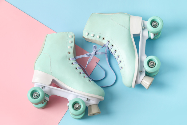 Roller skates with tied in bow on color background - Photo, Image
