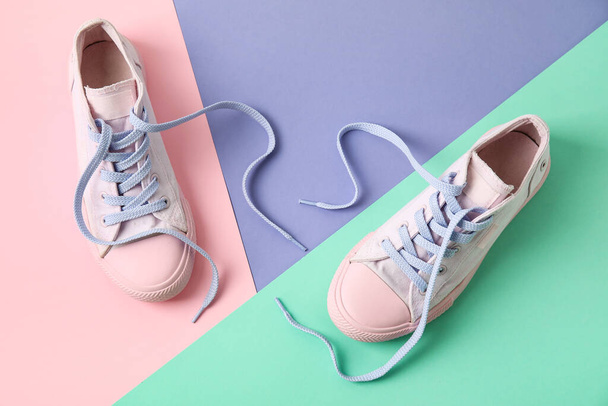Ζεύγος παπουτσιών με λυτά κορδόνια στο φόντο του χρώματος - Φωτογραφία, εικόνα