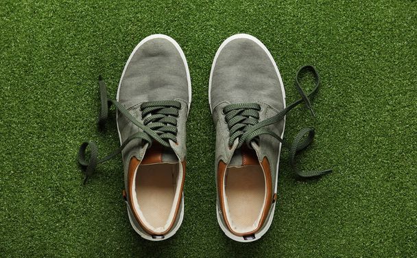 Par de zapatos casuales con cordones desatados sobre fondo de color - Foto, imagen
