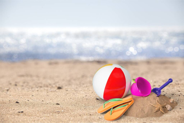 Flip-flops with ball and toys on sandy beach - Foto, immagini