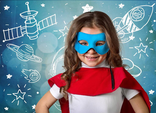 little girl in a superhero costume on a cosmic background - Foto, afbeelding