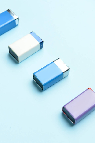 Baterías alcalinas en fila sobre fondo azul - Foto, Imagen