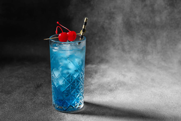Glass of Blue Lagoon cocktail on dark background - Foto, Imagem