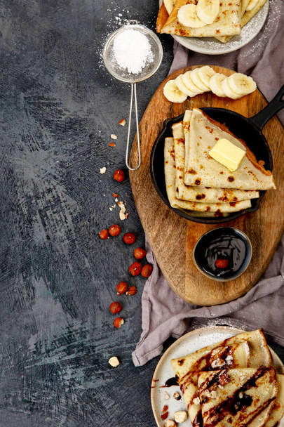 Crepes with sweet toppings on dark background. Homemade food concept. Top view, flat lay, copy space - Фото, изображение