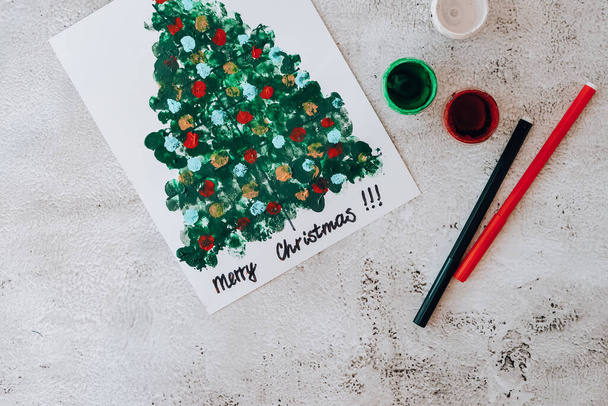 DIY Making greeting card Handmade crafts on holiday for children. Step by step. Do it yourself. Happy New Year xmas tree decoration Paint with fingers Merry Christmas tree. Top view. - Fotoğraf, Görsel
