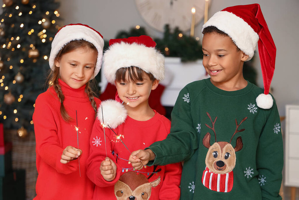 Söpöt pienet lapset tähtisädetikkujen kanssa kotona jouluaattona - Valokuva, kuva