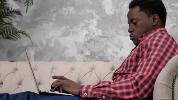 Афроамериканський бізнесмен працює в портативному онлайн-розмові з працівниками компанії. - Кадри, відео