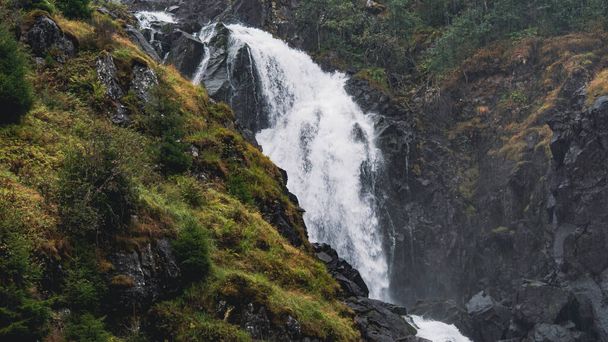 A beautiful panoramic view of a waterfall stream between woody cliffs in Norway - Foto, Imagen