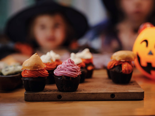 Boldog Halloweent! Tököt, cukorkát, sütit, muffint, cukorkát az asztalon az otthonban. Felkészülés a nyaralásra. - Fotó, kép