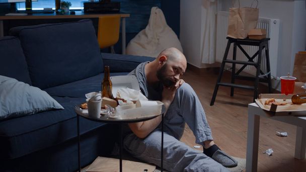 Frustrovaný nemocný muž sedí na podlaze a cítí stres - Fotografie, Obrázek