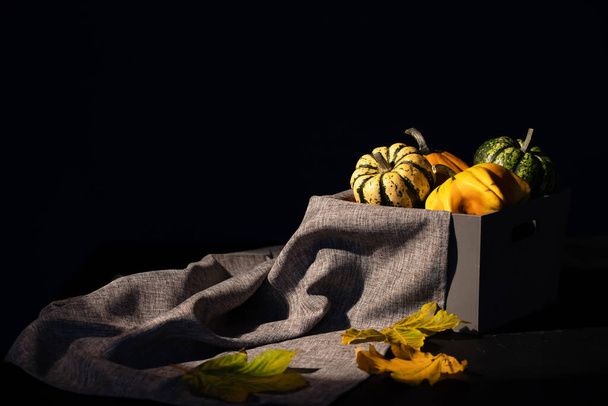 Rustic autumn still life with pumpkins and a basket on a wooden table. Halloween and Thanksgiving concept. - Zdjęcie, obraz