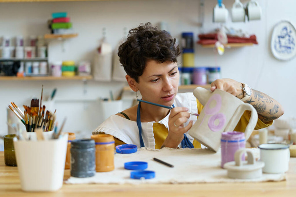 Young artistic woman small business owner work in studio with pottery and ceramics for handmade shop - Foto, immagini