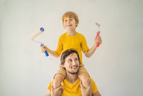 Father and son painting a wall in their home do it in the course of moving in - Zdjęcie, obraz