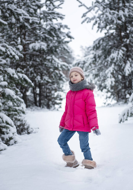 Dziecko w zimie. Mała dziewczynka, bawiąca się zimą na zewnątrz. Piękny zimowy portret dziecka. Szczęśliwe dziecko, zima zabawy na świeżym powietrzu. - Zdjęcie, obraz