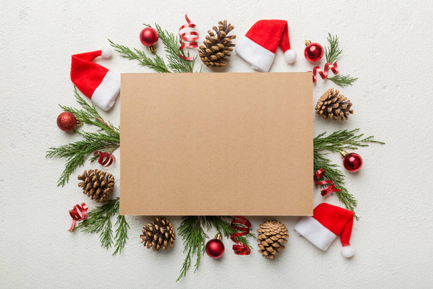 Flat lay composizione natalizia. quadrata Carta bianca, rami di pino, decorazioni natalizie su sfondo colorato. Vista dall'alto, copia lo spazio per il testo. - Foto, immagini