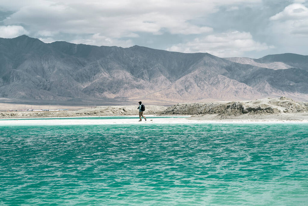 asiatico uomo maschio fotografo walking da un sale lago con rolling montagne in background - Foto, immagini