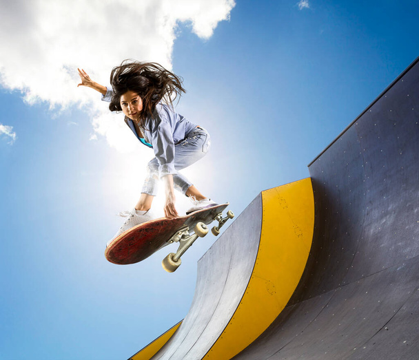 Skateboarder doing a jumping trick. Freestyle extreme sports concept - Fotó, kép