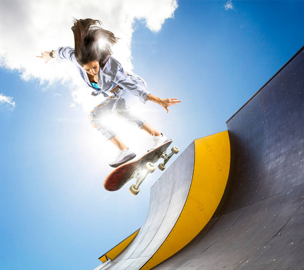 Skateboarder doing a jumping trick. Freestyle extreme sports concept - Photo, Image