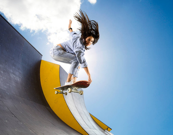 Skateboarder doing a jumping trick. Freestyle extreme sports concept - Zdjęcie, obraz