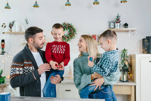 Cheerful happy married couple with two children waving hands laughing having fun at home for Christmas posing to camera indoor modern technology New Year congratulations to family or friends. - Valokuva, kuva