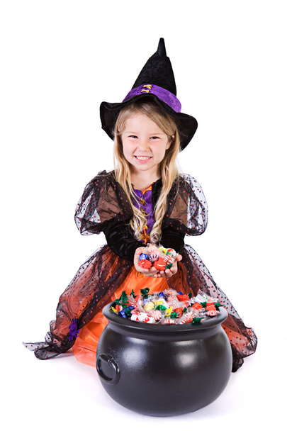 Halloween: Bruxa menina cava em pote de guloseimas de Halloween
 - Foto, Imagem
