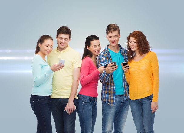 groep van lachende tieners met smartphones - Foto, afbeelding