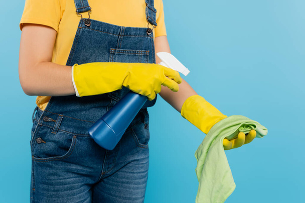 cropped view of housewife spraying cleanser on rag isolated on blue - Foto, Imagem