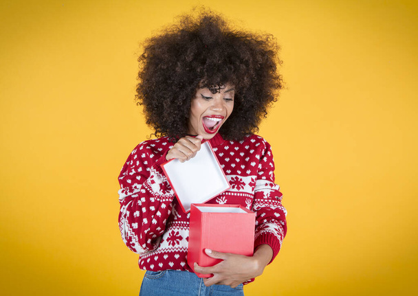 bonita mujer abriendo regalo de Navidad, feliz, fondo amarillo - Foto, Imagen