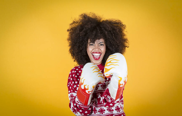 pretty latin hispanic woman at christmas, with boxing gloves. Yellow background - Foto, Imagem
