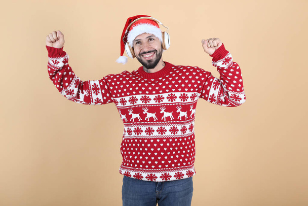 latino latino man, met kerst met kerstman hoed glimlachende gele achtergrond - Foto, afbeelding