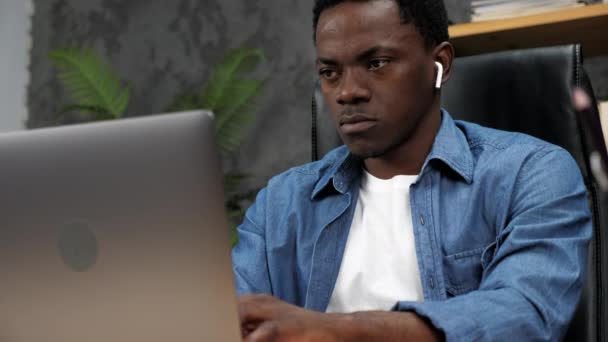 Афроамериканец работает в онлайновом чате с сотрудниками компании - Кадры, видео