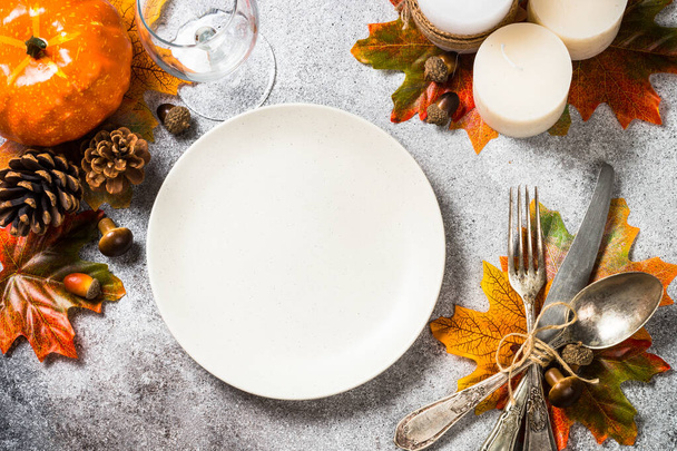 Jesienny stół z białą płytą, świecami i dekoracjami jesiennymi. - Zdjęcie, obraz