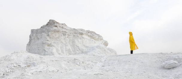 Man lost on a white stalker mountain in fog wearing yellow raincoat - Valokuva, kuva