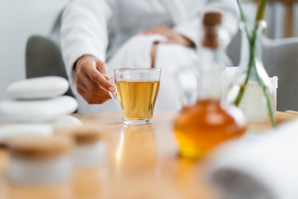 vue recadrée de la femme atteignant tasse de thé en verre - Photo, image