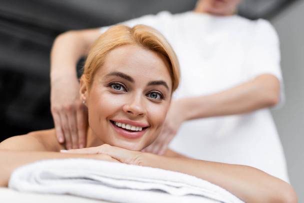 masseur faire massage des épaules à client joyeux dans le centre de spa - Photo, image