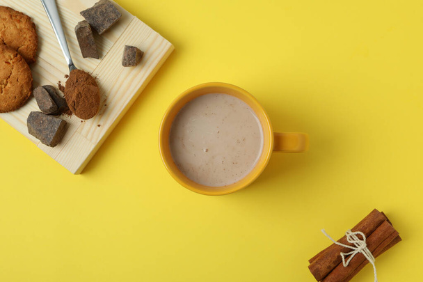 Concept of tasty drink with cocoa on yellow background - Photo, image