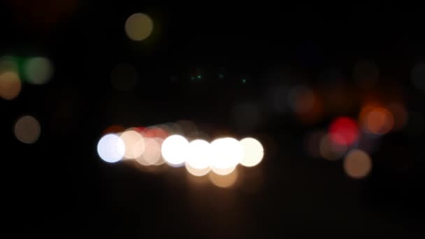 Прекрасний блискучий боке в темному розмитому фоні вночі. Круглий барвистий боке світиться від автомобільних вогнів на міській вулиці. За межами фокусу з розмитістю. Неорієнтовані міські вогні. Рухомий боке. Анотація
 - Кадри, відео
