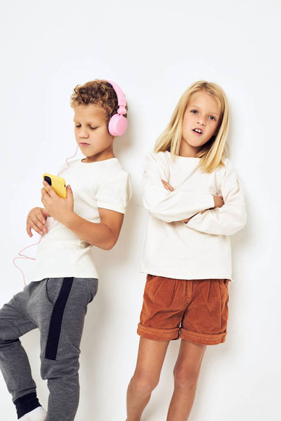 Dvě předškolní děti chlapec a dívka usmívá s telefonem v ruce módní izolované pozadí - Fotografie, Obrázek