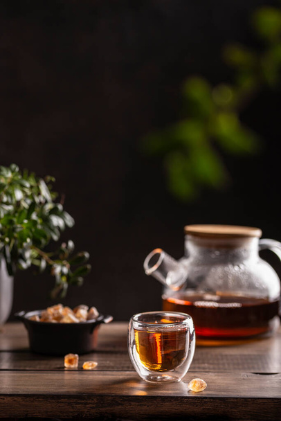 Black hot tea with sugar lollipops on a wooden table - Фото, зображення