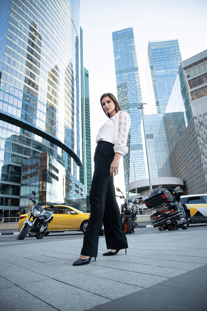 Young business woman with modern skyscrapers behind in black and white - Foto, immagini