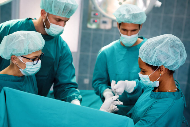 Portrait of a successful medical surgeon team inside operating room, ready to work in hospital - Foto, afbeelding