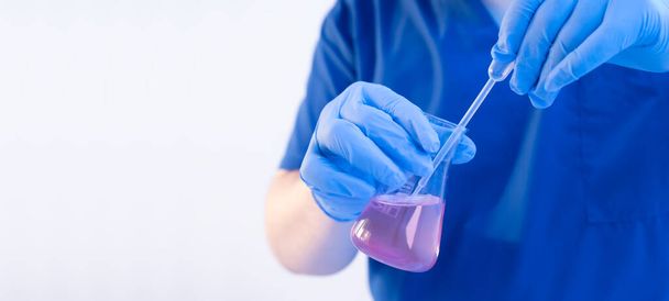 Close up chemical scientist developing a new drug by adding new element with disposable pipette. Wide banner with white copy space - Фото, зображення