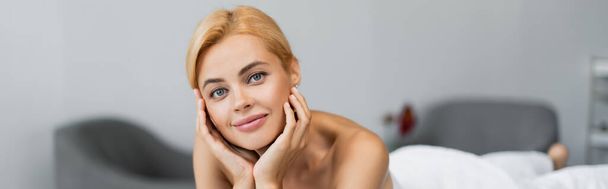 happy blonde client looking at camera in spa center, banner - Foto, Bild