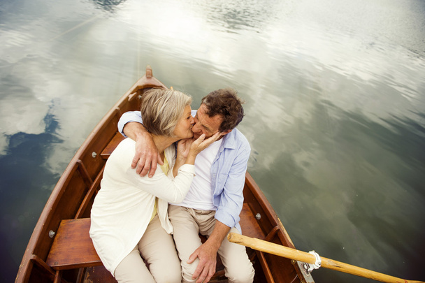 Senior couple kissing on boat - Photo, image