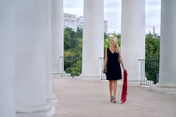 Beautiful Woman in a dress among the white columns of an architectural arch. Odessa. Ukraine. - 写真・画像
